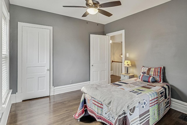 bedroom featuring a ceiling fan, baseboards, and wood finished floors