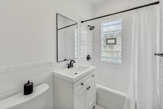 bathroom featuring toilet, tile walls, shower / bath combo, and vanity