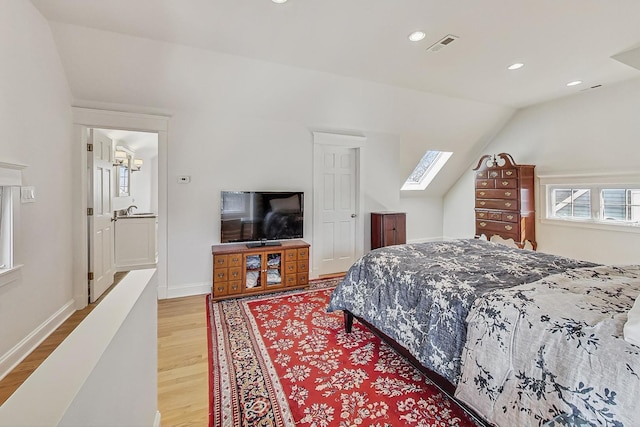 bedroom with light wood-type flooring, lofted ceiling with skylight, visible vents, recessed lighting, and baseboards