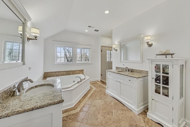 bathroom with two vanities, a whirlpool tub, a sink, a shower stall, and vaulted ceiling