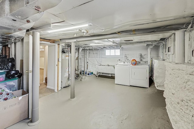 below grade area featuring a sink, water heater, and washer and clothes dryer