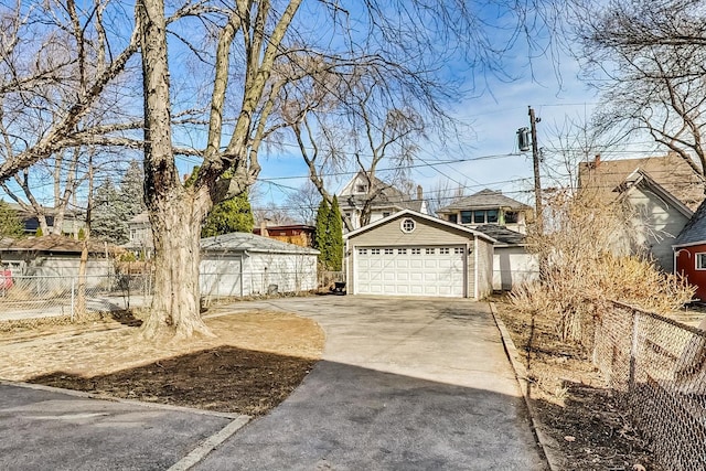 view of yard featuring an outdoor structure, fence, a garage, and driveway