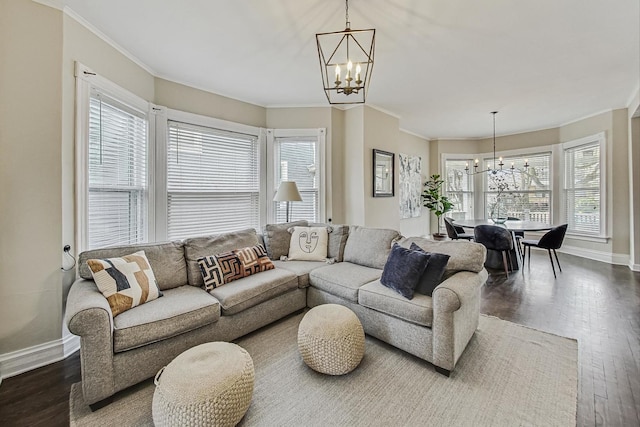 living area with baseboards, dark wood-type flooring, a healthy amount of sunlight, and a chandelier