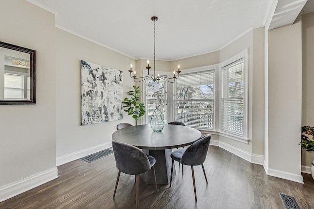 dining room featuring dark wood-style floors, visible vents, and an inviting chandelier