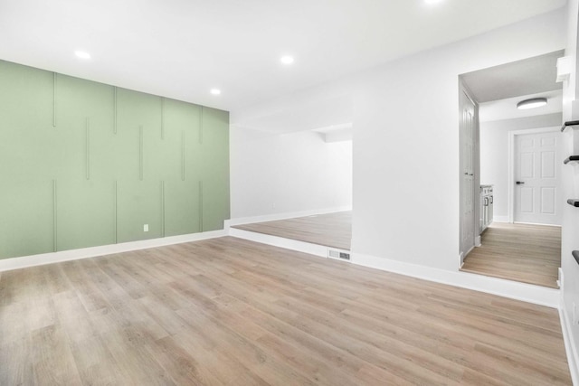 empty room featuring recessed lighting, light wood-style floors, and visible vents