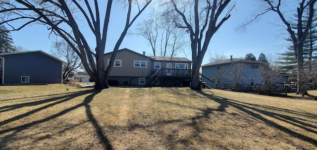 rear view of property featuring stairway and a yard