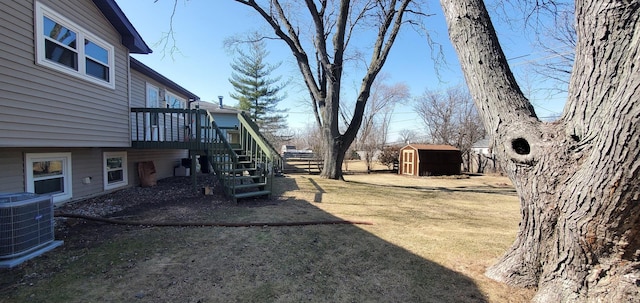 view of yard featuring a wooden deck, stairs, cooling unit, a storage shed, and an outdoor structure