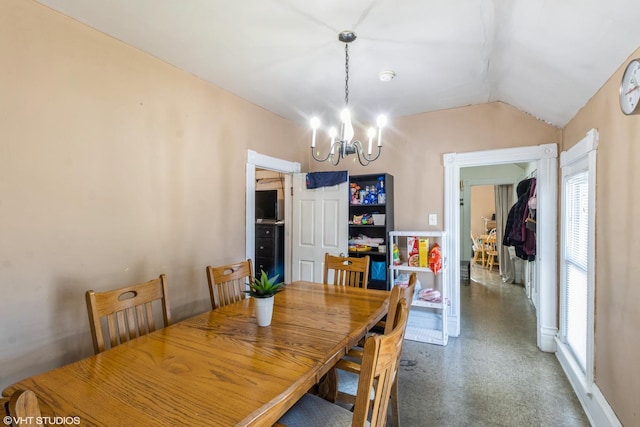 dining area featuring a notable chandelier and lofted ceiling