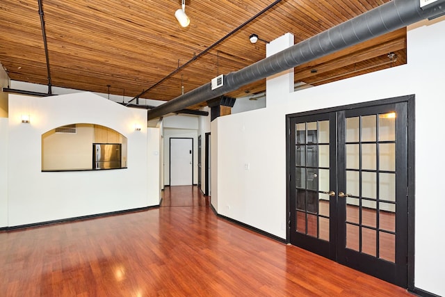 spare room featuring visible vents, wood finished floors, french doors, wooden ceiling, and baseboards