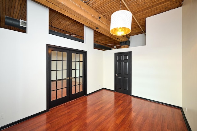 empty room featuring wood finished floors, baseboards, wood ceiling, french doors, and beamed ceiling