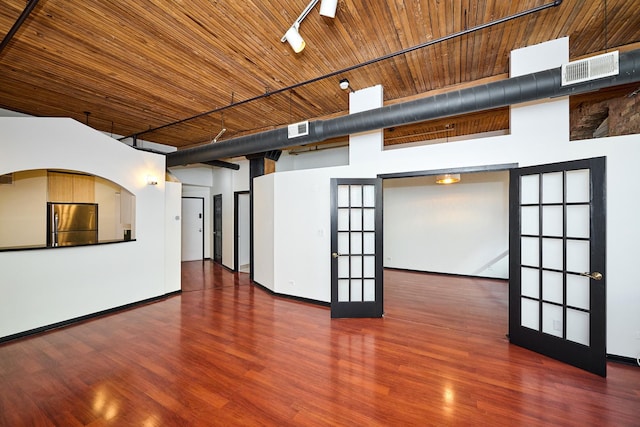 unfurnished living room featuring visible vents, wood finished floors, french doors, a high ceiling, and wooden ceiling