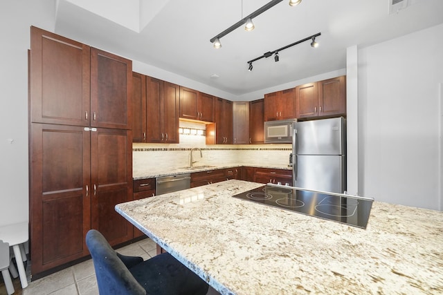 kitchen with light stone counters, light tile patterned floors, a sink, decorative backsplash, and appliances with stainless steel finishes