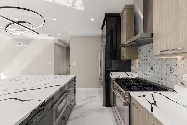 kitchen featuring wall chimney range hood, light brown cabinetry, marble finish floor, stainless steel appliances, and recessed lighting
