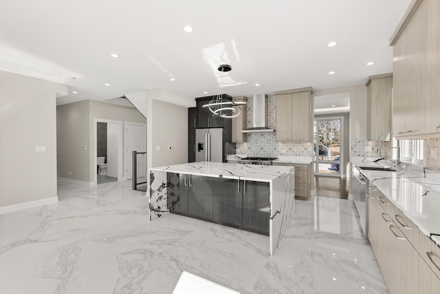 kitchen featuring a spacious island, wall chimney range hood, tasteful backsplash, a sink, and appliances with stainless steel finishes