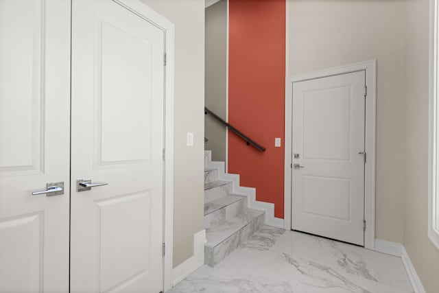 stairway with baseboards and marble finish floor