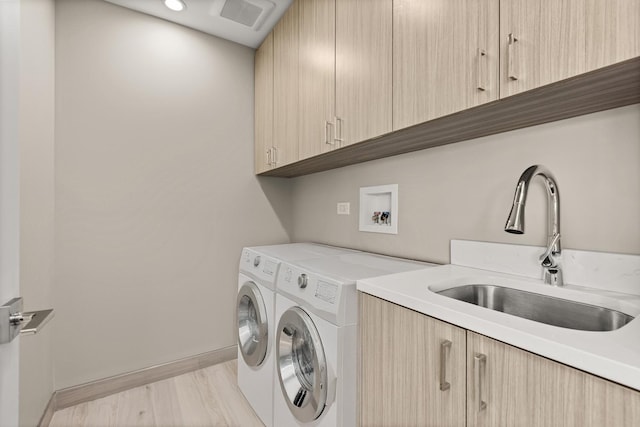laundry room featuring a sink, baseboards, hookup for a washing machine, and cabinet space