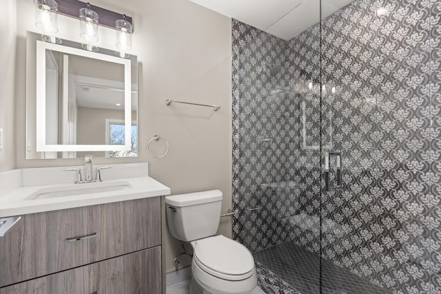 full bathroom with vanity, a shower stall, and toilet