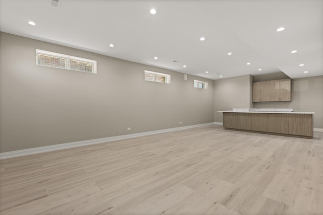 unfurnished living room featuring baseboards, recessed lighting, and light wood-style flooring
