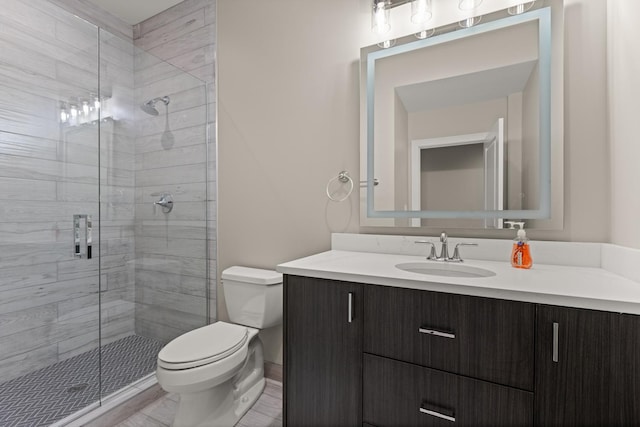 bathroom with vanity, toilet, and a shower stall