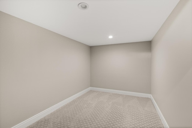 spare room featuring baseboards, recessed lighting, and light colored carpet