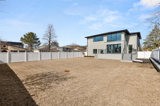 back of property featuring a fenced backyard