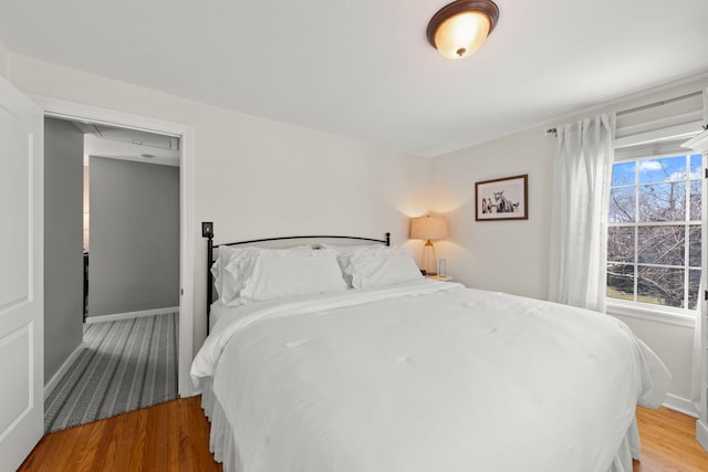 bedroom with baseboards and wood finished floors