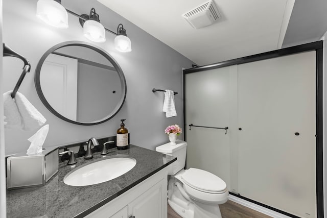 full bathroom with visible vents, a shower stall, vanity, and toilet
