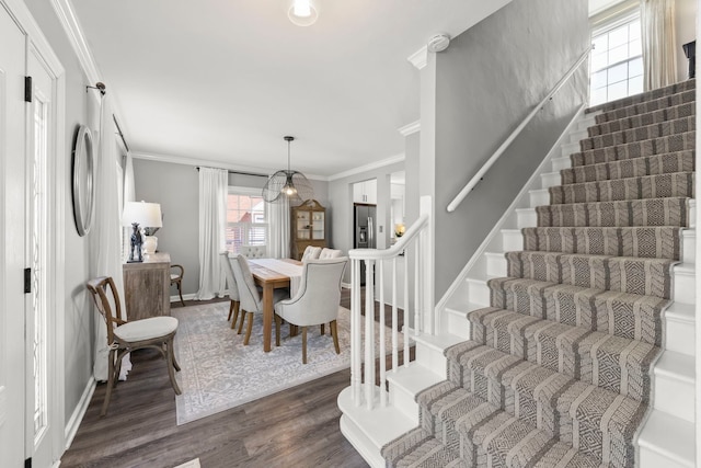 dining room featuring dark wood finished floors, stairway, baseboards, and ornamental molding