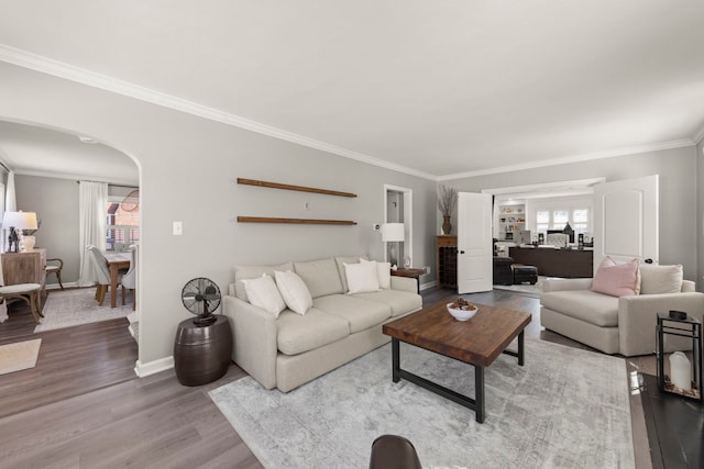 living room with arched walkways, plenty of natural light, ornamental molding, and wood finished floors