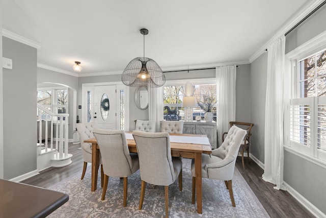 dining room featuring baseboards, arched walkways, dark wood-style floors, and ornamental molding