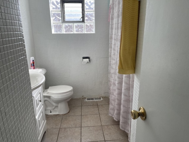 full bathroom featuring tile patterned flooring, visible vents, toilet, a shower with shower curtain, and vanity