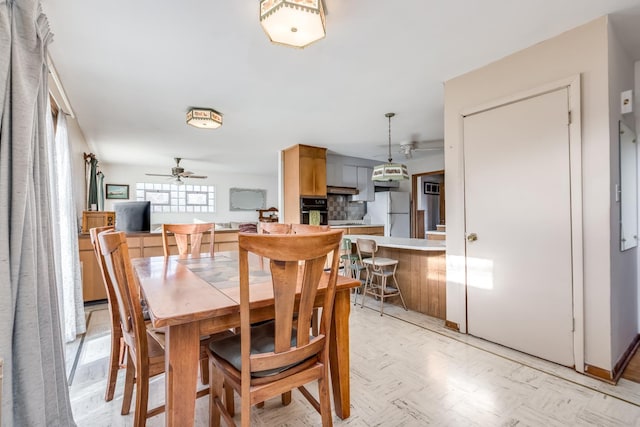 dining space featuring light floors and a ceiling fan