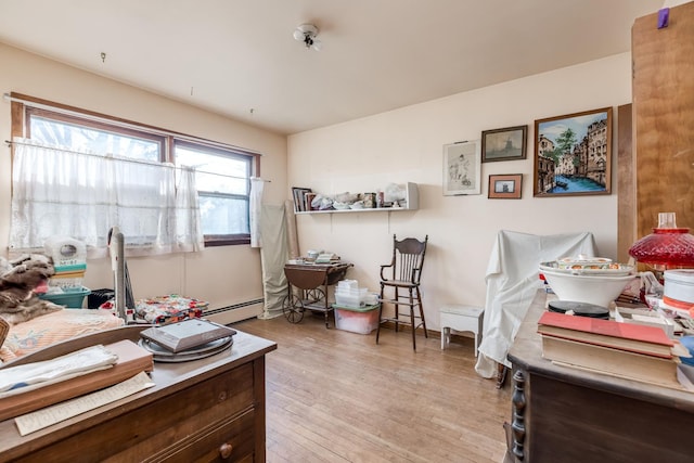 office space featuring light wood finished floors and a baseboard radiator