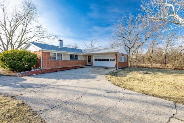 ranch-style home featuring concrete driveway, a front yard, an attached garage, brick siding, and a chimney