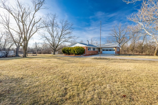 view of front of home featuring a front yard, an attached garage, brick siding, and concrete driveway