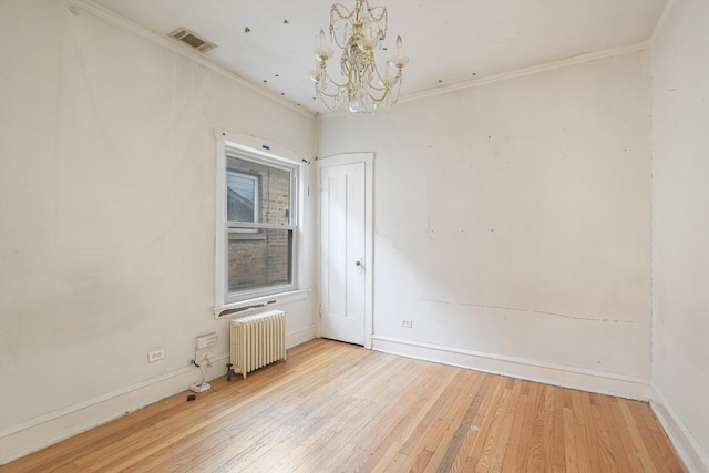 unfurnished room with light wood-type flooring, visible vents, radiator, crown molding, and a chandelier