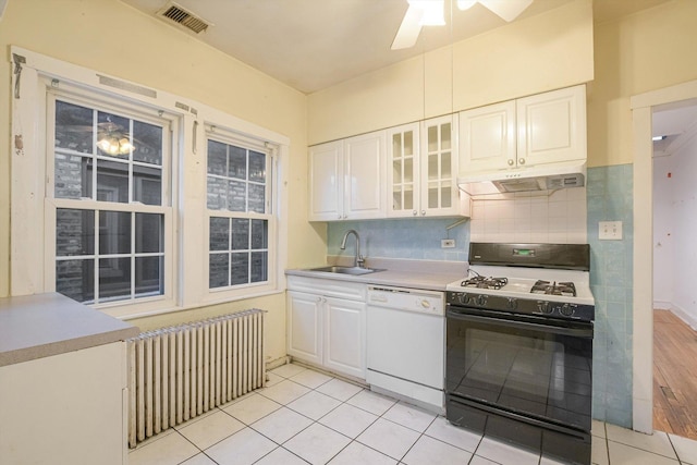 kitchen with under cabinet range hood, a sink, gas stove, radiator, and dishwasher