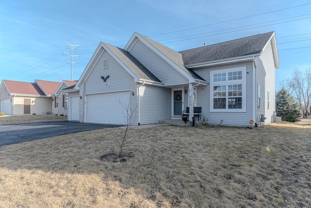 ranch-style home with aphalt driveway, a front yard, an attached garage, and a shingled roof