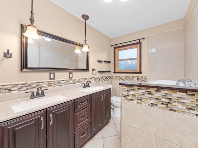 full bathroom with tile patterned flooring, tile walls, toilet, and a sink