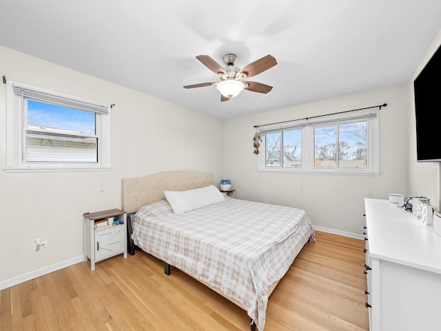 bedroom featuring light wood-style flooring, a ceiling fan, and baseboards