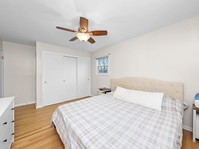 bedroom featuring a closet, light wood-type flooring, and baseboards