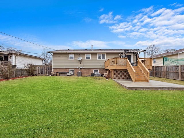 rear view of property with a fenced backyard, a yard, stairway, a wooden deck, and a patio area