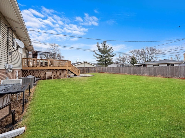 view of yard with a deck, a fenced backyard, and stairs