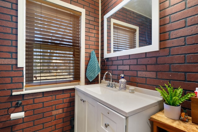 bathroom with brick wall and vanity