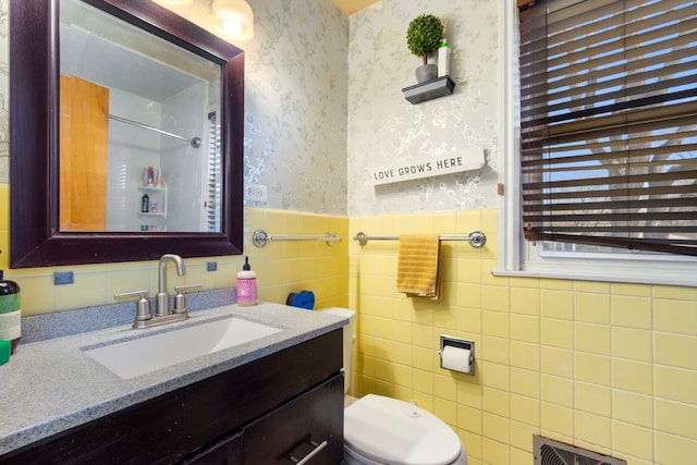 full bath featuring visible vents, wallpapered walls, a wainscoted wall, toilet, and vanity