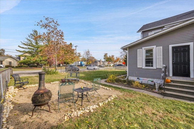 view of yard with a fire pit and fence