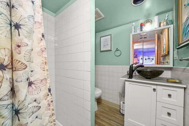 1418 N Mayfield Ave, Chicago, IL 60651 - full bath with tile walls, vanity, wood finished floors, curtained shower, and a wainscoted wall