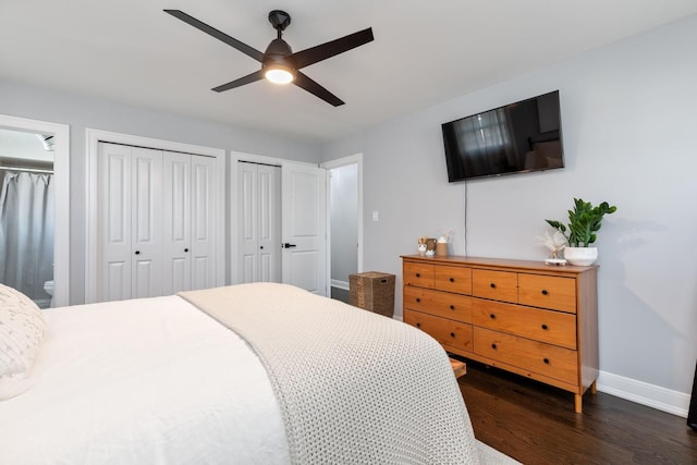 bedroom featuring baseboards, two closets, dark wood finished floors, and a ceiling fan