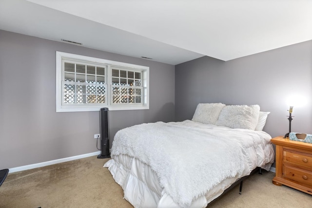 bedroom with visible vents, baseboards, and light carpet