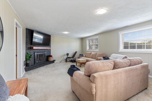 living area with a textured ceiling, a fireplace, and carpet flooring